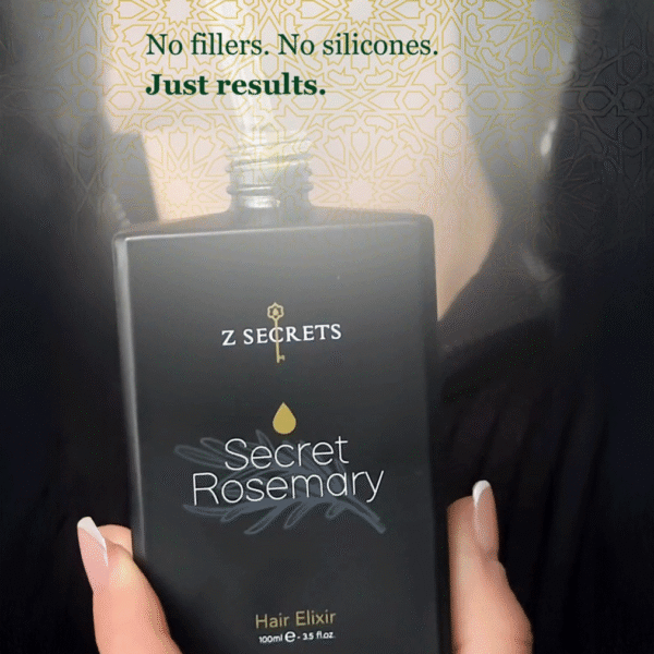 A lady holds a black bottle labelled Z Secrets Secret Rosemary Hair Elixir with gold accents. Text above reads: No fillers. No silicones. Just results. An organic hair care routine essential. Z Secrets gold Zelieg geometric pattern is visible in the background.